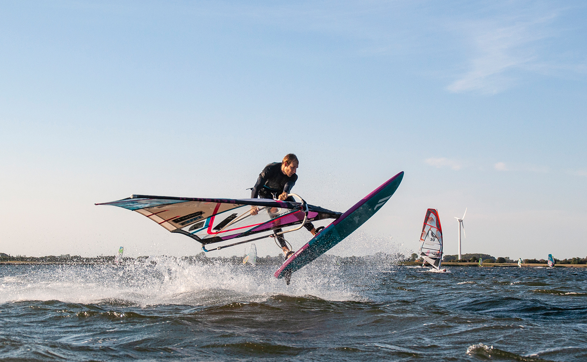 Windsurfen Freestyler Bastian Grimm in Wulfen auf Fehmarn im Flug beim Shaka