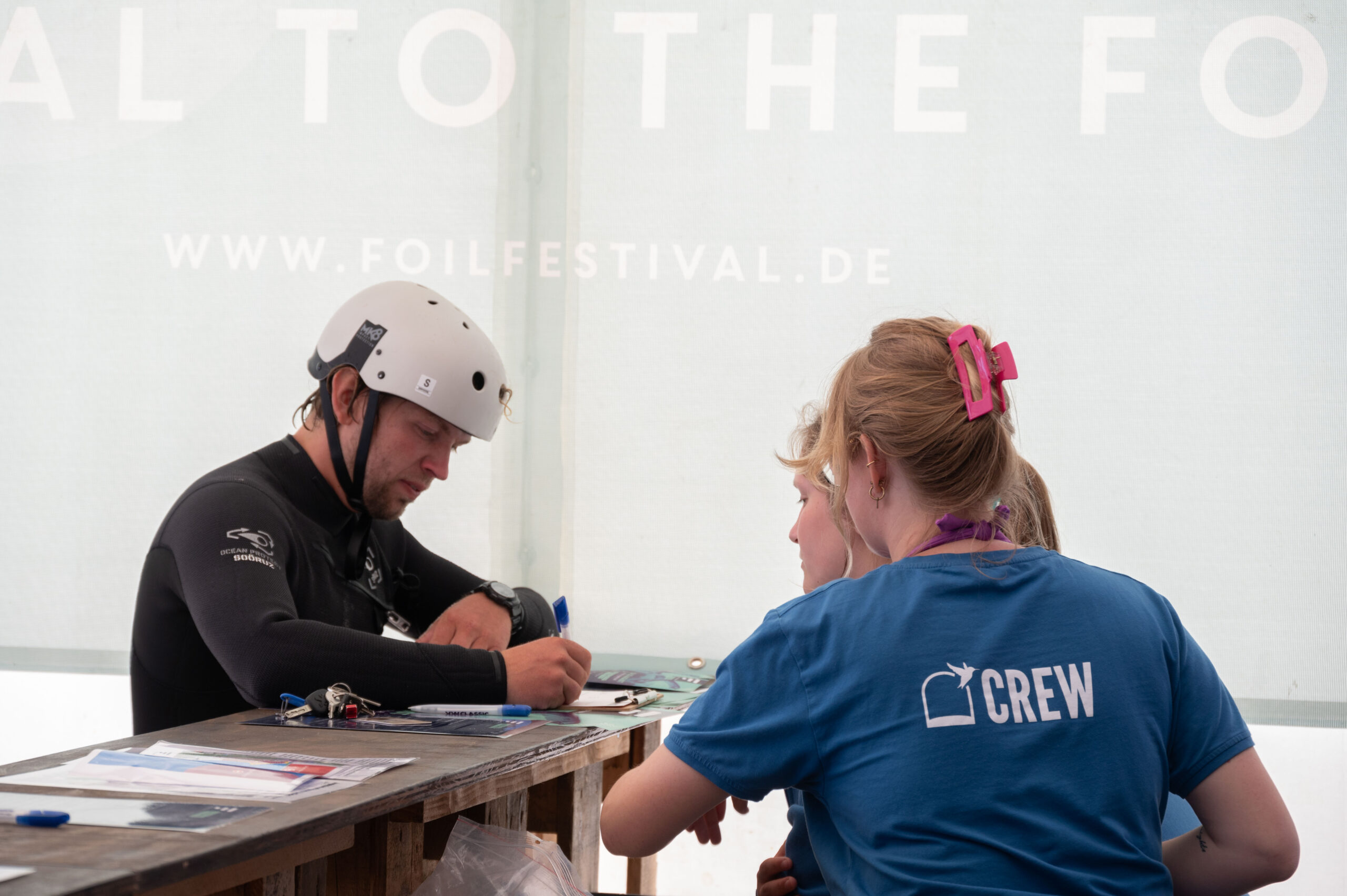Foilfestival Einschreibung, Mann am Tresen füllt Formular aus